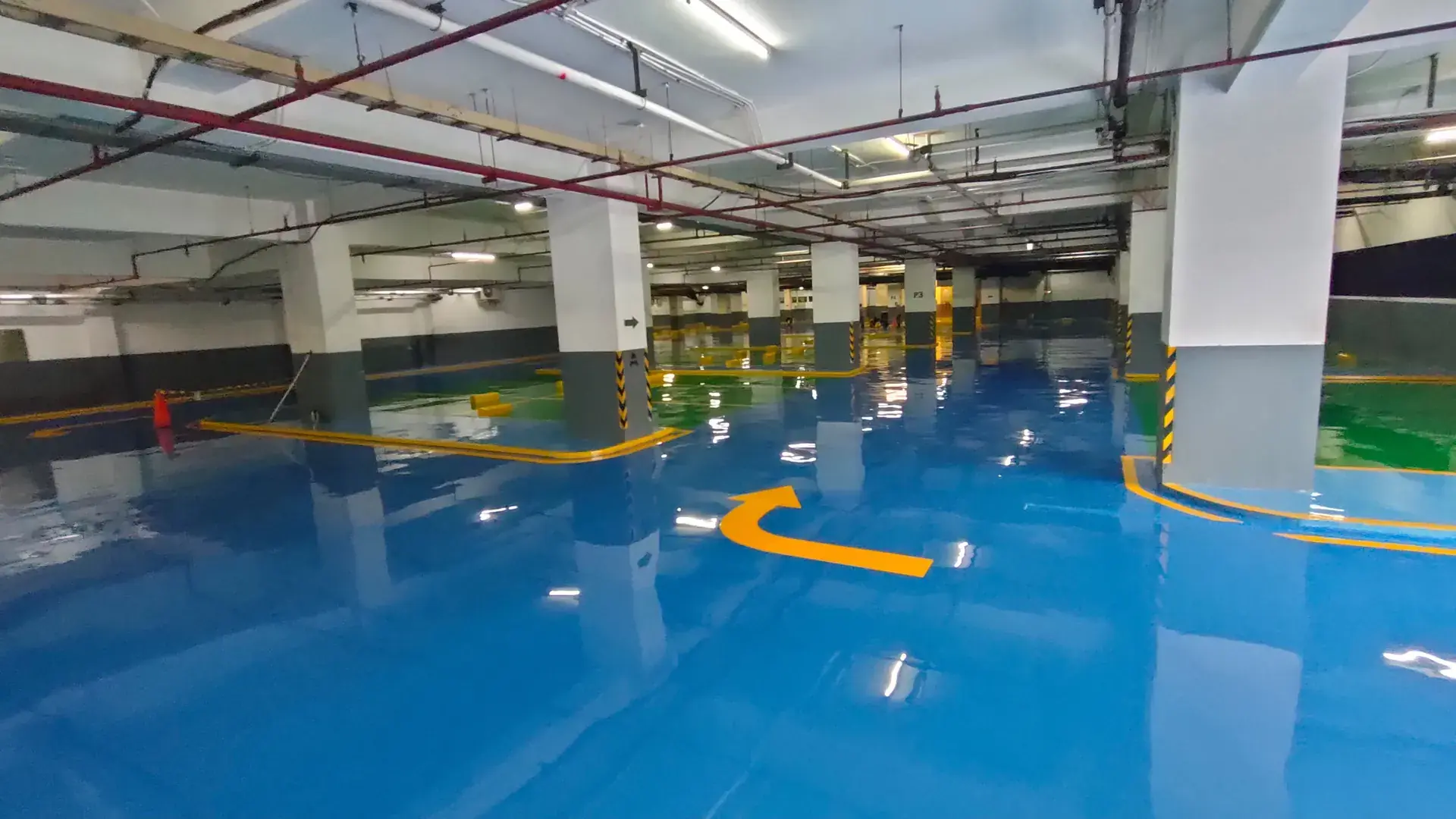 Lantai epoxy biru dengan marka parkir di basement