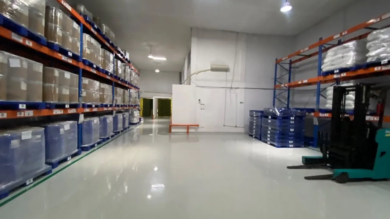 Lantai epoxy gudang dengan rak dan jalur forklift