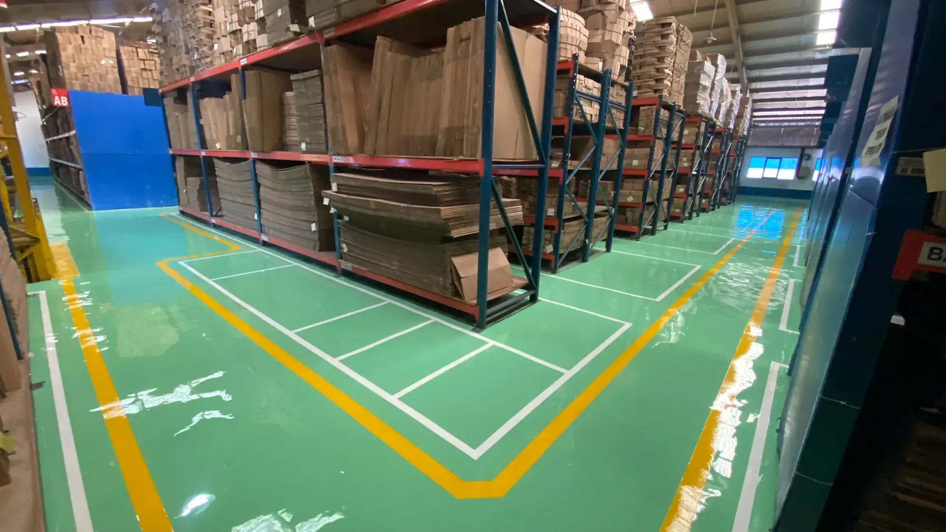 Lantai epoxy hijau dengan marka di gudang rak