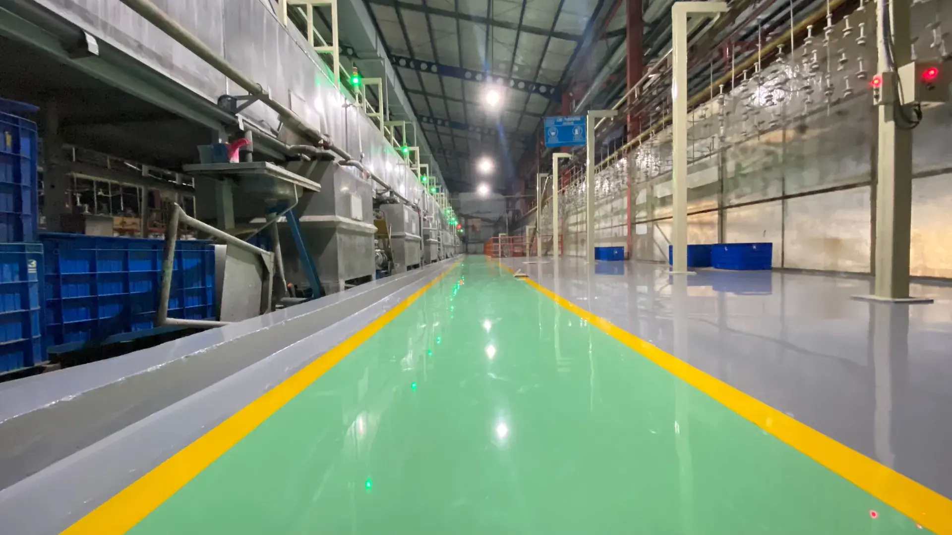 Lantai epoxy hijau dengan marka jalur kuning di lorong produksi pabrik