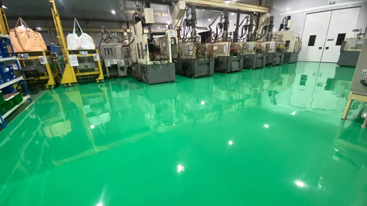 Lantai epoxy hijau glossy di pabrik dengan deretan mesin produksi
