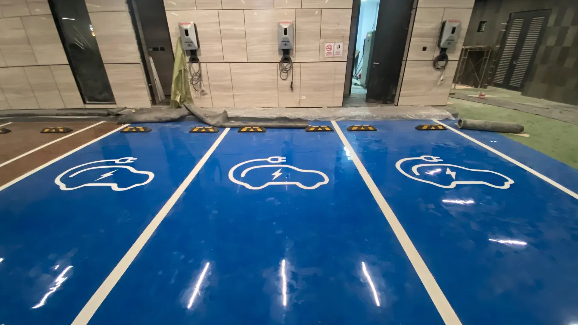 Marka parkir mobil listrik di lantai epoxy biru